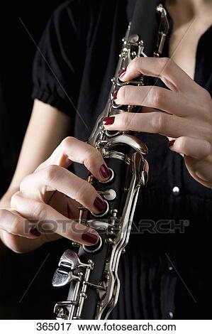 Woman playing a clarinet View Large Photo Image Stock Photo - Woman playing a clarinet. Fotosearch