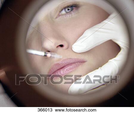Reflection in mirror of surgeon giving woman a Botox injection View Large Photo Image Stock Image - Reflection in mirror of surgeon giving woman a Botox injection. Fotosearch