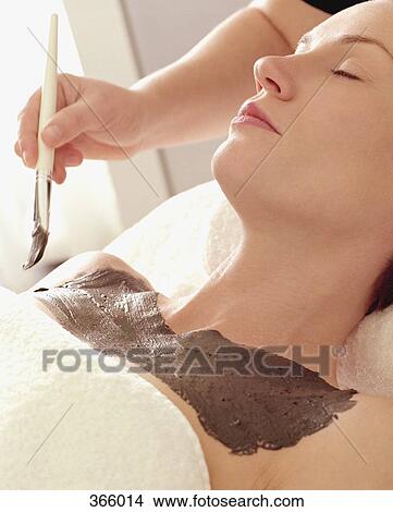 Picture - Woman having body mask applied at beauty spa. Fotosearch