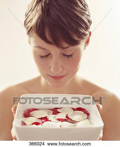 Woman holding a bowl of water with rose petals View Large Photo Image Picture - Woman holding a bowl of water with rose petals. Fotosearch