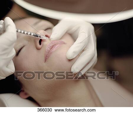 Stock Image - Woman receiving a Botox injection. Fotosearch