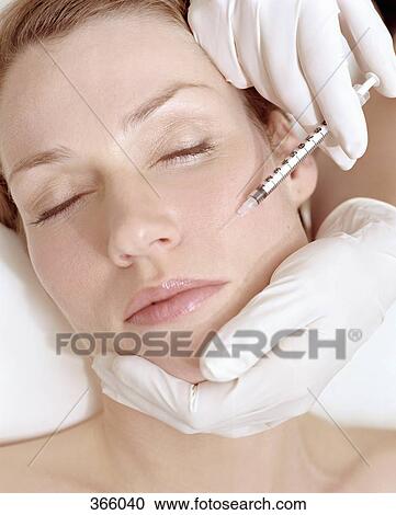 Stock Image - Woman receiving a Botox injection. Fotosearch