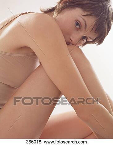 Woman sitting curled up with chin on knee View Large Photo Image Stock Photography - Woman sitting curled up with chin on knee. Fotosearch