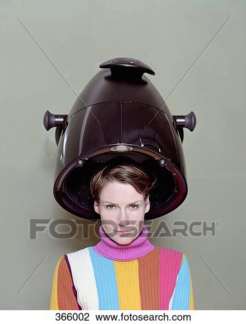 Woman sitting under a hair dryer in a hair salon View Large Photo Image Stock Image - Woman sitting under a hair dryer in a hair salon. Fotosearch