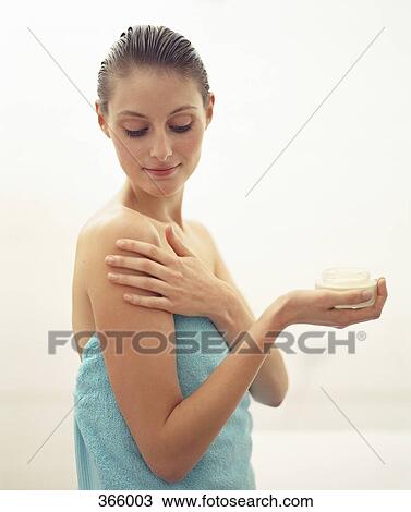 Woman wrapped in a towel and applying moisturizer View Large Photo Image Stock Image - Woman wrapped in a towel and applying moisturizer. Fotosearch