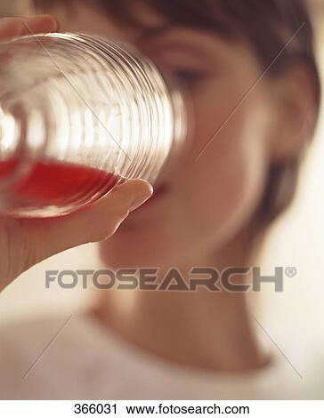 Young woman drinking juice from a glass View Large Photo Image Stock Image - Young woman drinking juice from a glass. Fotosearch