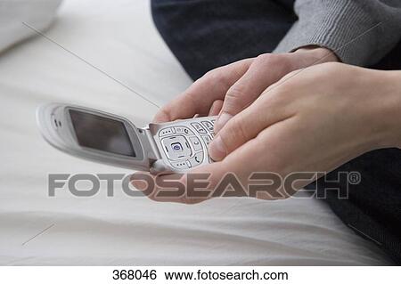 Close-up of hand holding mobile phone View Large Photo Image Stock Photograph - Close-up of hand holding mobile phone. Fotosearch