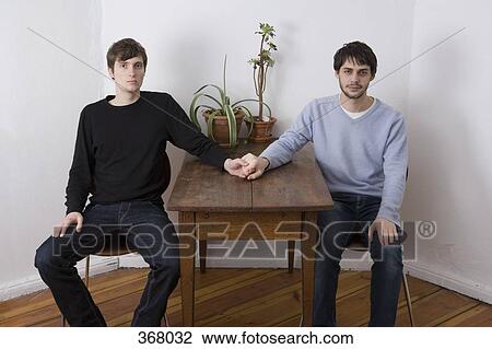 Young gay couple holding hands across table View Large Photo Image Stock Image - Young gay couple holding hands across table. Fotosearch