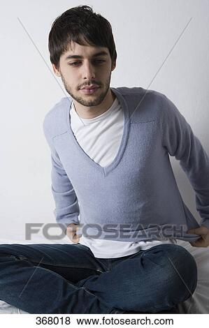 Young man getting dressed View Large Photo Image Stock Photo - Young man getting dressed. Fotosearch