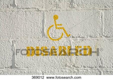Stock Image - Disabled parking sign on a brick wall. Fotosearch