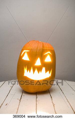 Illuminated Jack O’Lantern on a table View Large Photo Image Picture - Illuminated Jack O’Lantern on a table. Fotosearch