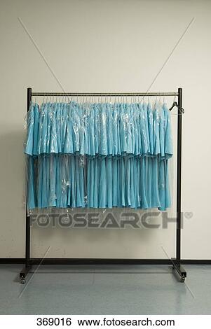 Row of blue shirts hanging on clothes rack View Large Photo Image Stock Photograph - Row of blue shirts hanging on clothes rack. Fotosearch