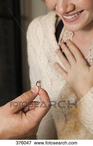 Stock Photo - Man giving a ring to a young woman. Fotosearch