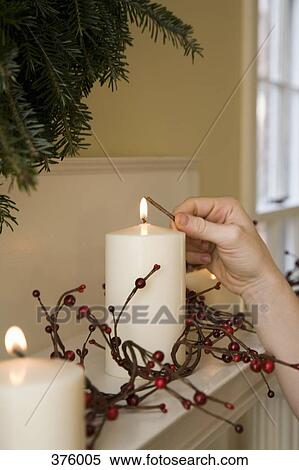 Woman lighting candles on a mantelpiece View Large Photo Image Stock Photography - Woman lighting candles on a mantelpiece. Fotosearch