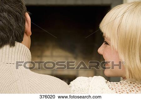 Young couple sitting in front of an open fire together View Large Photo Image Stock Image - Young couple sitting in front of an open fire together. Fotosearch