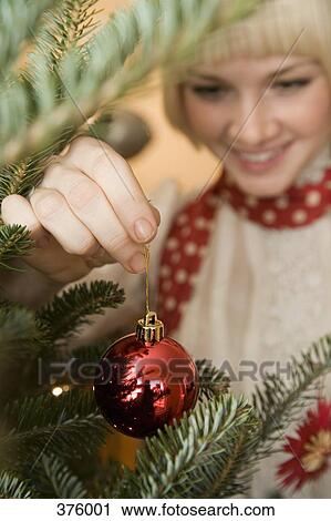 Young woman decorating a Christmas tree View Large Photo Image Stock Image - Young woman decorating a Christmas tree. Fotosearch
