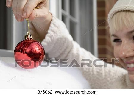 Young woman holding a Christmas bauble View Large Photo Image Stock Image - Young woman holding a Christmas bauble. Fotosearch