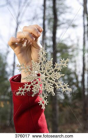 Young woman holding a decorative snowflake View Large Photo Image Stock Photo - Young woman holding a decorative snowflake. Fotosearch