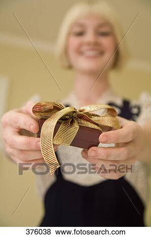 Stock Photo - Young woman holding a present. Fotosearch