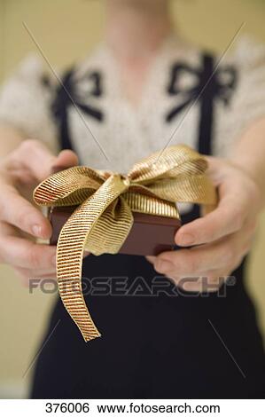 Young woman holding a present View Large Photo Image Stock Photograph - Young woman holding a present. Fotosearch