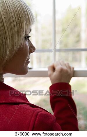 Young woman looking out a window View Large Photo Image Stock Image - Young woman looking out a window. Fotosearch
