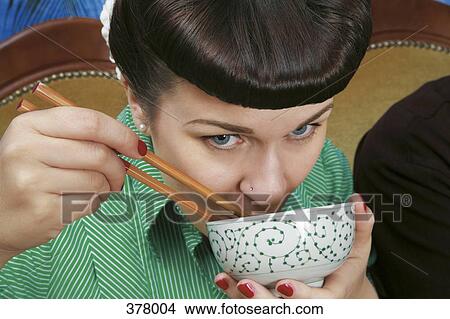 Close up of young rockabilly woman holding soup bowl and chopsticks View Large Photo Image Picture - Close up of young rockabilly woman holding soup bowl and chopsticks. Fotosearch