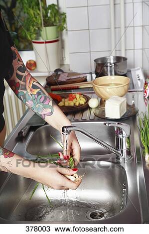 Woman washing vegetables at sink, with tattooed arm View Large Photo Image Stock Image - Woman washing vegetables at sink, with tattooed arm. Fotosearch