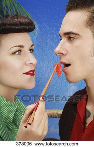 Stock Photograph - Young rockabilly couple eating sushi. Fotosearch