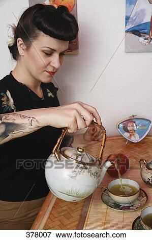 Young rockabilly woman pouring tea View Large Photo Image Stock Photo - Young rockabilly woman pouring tea. Fotosearch