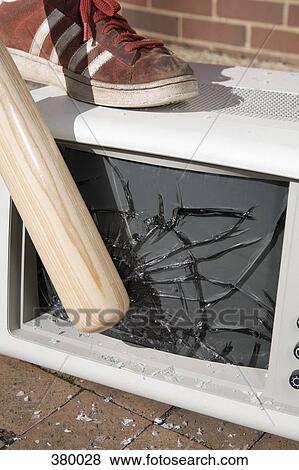 Stock Photo - Man holding a baseball bat to a smashed monitor. Fotosearch