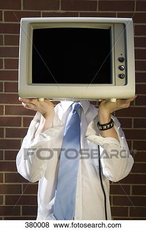 Man holding a television in front of his face View Large Photo Image Stock Photo - Man holding a television in front of his face. Fotosearch