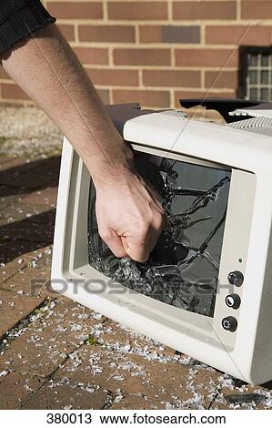 Man holding his fist to a smashed television View Large Photo Image Stock Image - Man holding his fist to a smashed television. Fotosearch