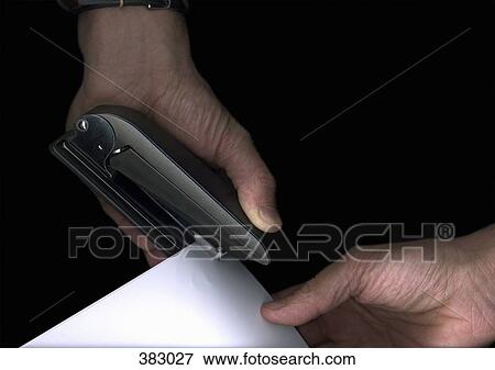 Stock Photo - Man using a stapler. Fotosearch
