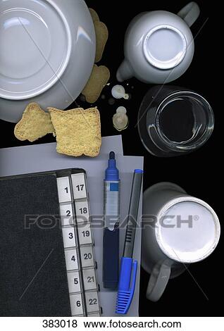 Stock Photo - Office supplies surrounded by food and dishes. Fotosearch