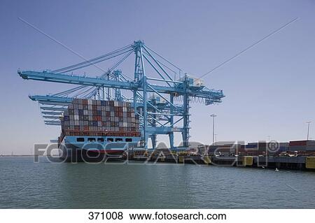 Container ship below cranes at a commercial dock View Large Photo Image Stock Photo - Container ship below cranes at a commercial dock. Fotosearch