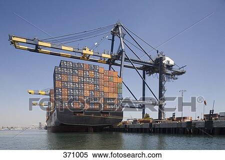 Container ship below cranes at a commercial dock View Large Photo Image Stock Photography - Container ship below cranes at a commercial dock. Fotosearch