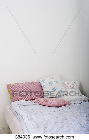 Stock Photograph - Bed with patterned pillows and duvet. Fotosearch