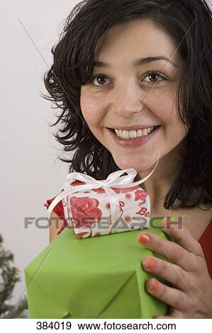 Woman holding gift and smiling View Large Photo Image Stock Photo - Woman holding gift and smiling. Fotosearch