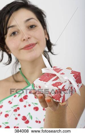 Woman looking at camera and holding present View Large Photo Image Stock Photo - Woman looking at camera and holding present. Fotosearch