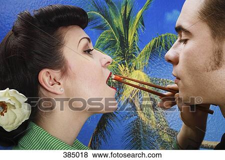 Stock Photo - Man feeding sushi to his girlfriend. Fotosearch