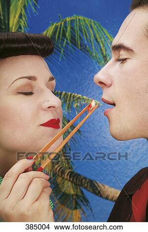 Woman feeding sushi to her boyfriend View Large Photo Image Picture - Woman feeding sushi to her boyfriend. Fotosearch