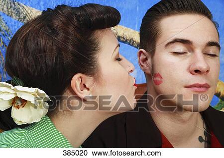 Stock Image - Woman giving her boyfriend a lipstick kiss . Fotosearch