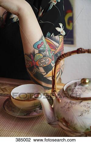 Woman's tattooed arm resting next to Japanese tea set View Large Photo Image Stock Image - Woman's tattooed arm resting next to Japanese tea set. Fotosearch