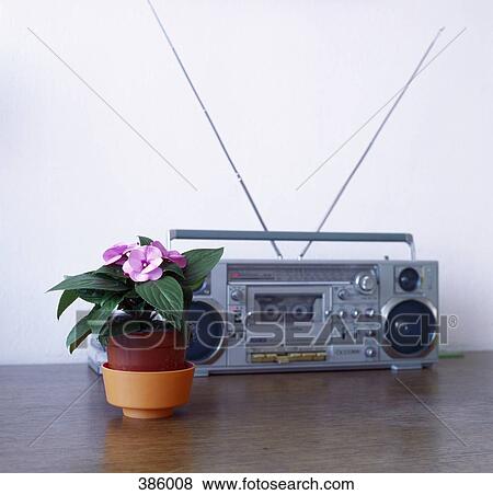Flower pot and radio cassette player on a wooden table View Large Photo Image Stock Photo - Flower pot and radio cassette player on a wooden table . Fotosearch