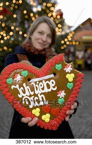 Woman holding up a heart-shaped gingerbread cookie with missing bites View Large Photo Image Stock Image - Woman holding up a heart-shaped gingerbread cookie with missing bites. Fotosearch