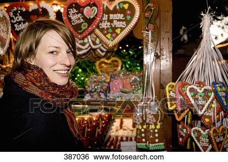 Woman standing at a market stall with heart-shaped gingerbread cookies, Berlin, Germany View Large Photo Image Stock Photograph - Woman standing at a market stall with heart-shaped gingerbread cookies, Berlin, Germany. Fotosearch
