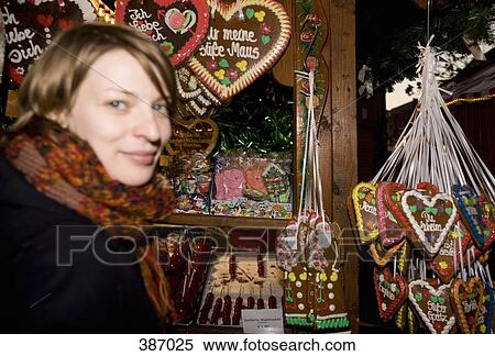 Woman standing at a market stall with heart-shaped gingerbread cookies, Berlin, Germany View Large Photo Image Stock Photography - Woman standing at a market stall with heart-shaped gingerbread cookies, Berlin, Germany. Fotosearch