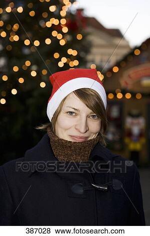 Woman wearing a Santa hat at a Christmas market, Berlin, Germany View Large Photo Image Stock Photo - Woman wearing a Santa hat at a Christmas market, Berlin, Germany. Fotosearch