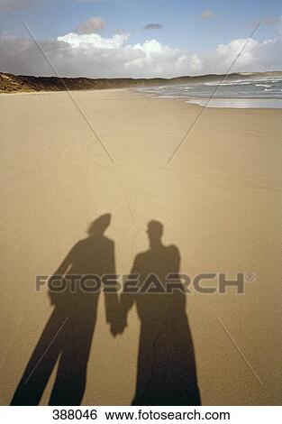 Couple holding hands on a beach View Large Photo Image Stock Photograph - Couple holding hands on a beach. Fotosearch