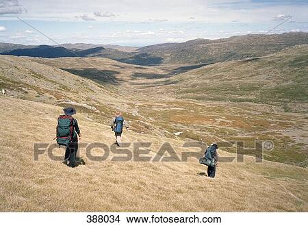Three people backpacking through hills View Large Photo Image Picture - Three people backpacking through hills. Fotosearch